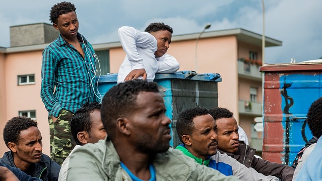 Junge Eritreer in einem Asylempfangszentrum sitzen auf dem Boden. Junge Eritreer in einem Asylempfangszentrum sitzen auf dem Boden.