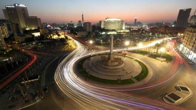 Langzeitbelichtung des Tahrir-Platzes am Abend. Die Lichter von Autos hinterlassen leuchtende Streifen. Langzeitbelichtung des Tahrir-Platzes am Abend. Die Lichter von Autos hinterlassen leuchtende Streifen.