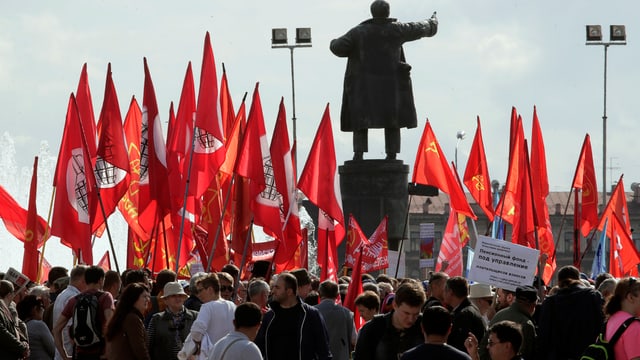 Demonstranten stehen um eine Lenin-Statue Demonstranten stehen um eine Lenin-Statue