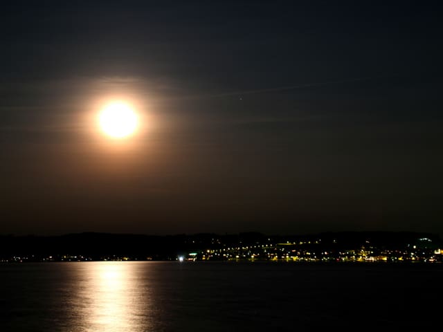 Der Murtensee reflektiert das Licht des Vollmondes.