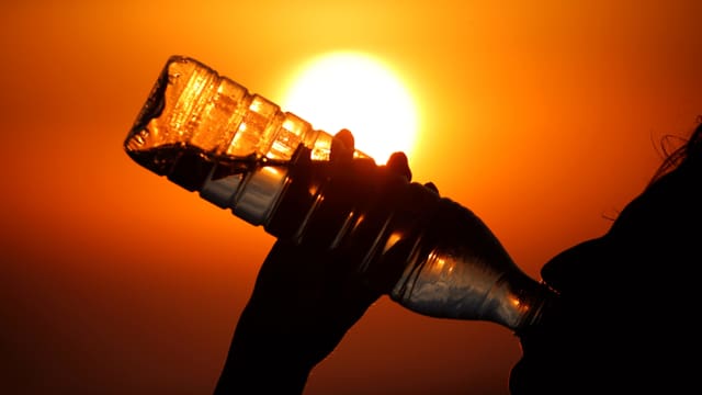 Person trinkt Wasser aus einer Petflasche. Person trinkt Wasser aus einer Petflasche.