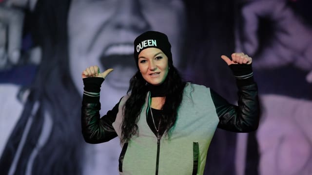 Rapperin posiert vor einem Graffiti von ihr Rapperin posiert vor einem Graffiti von ihr