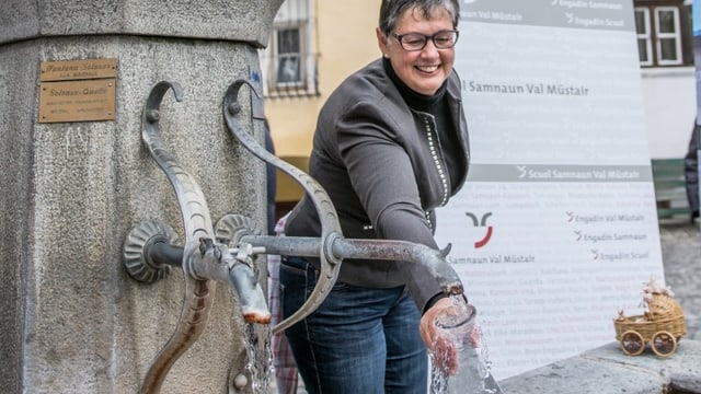 Frau holt mit Karaffe Wasser vom Brunnen. Frau holt mit Karaffe Wasser vom Brunnen.