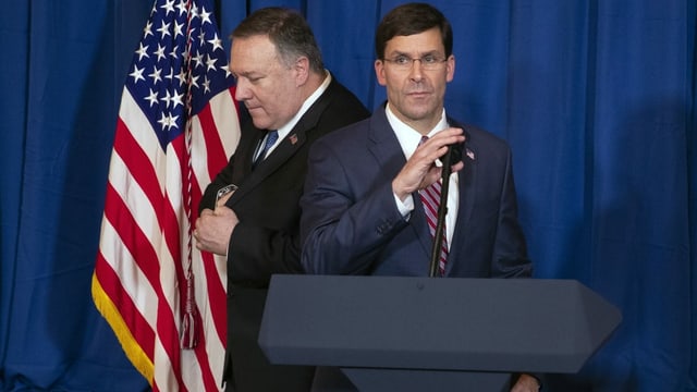 Mark Esper steht vor einem Rednerpult. Hinter ihm geht Mike Pompeo vorbei. Mark Esper steht vor einem Rednerpult. Hinter ihm geht Mike Pompeo vorbei.