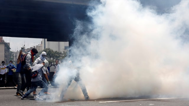 Demonstranten und Polizei, eine Rauchwolke steigt auf Demonstranten und Polizei, eine Rauchwolke steigt auf