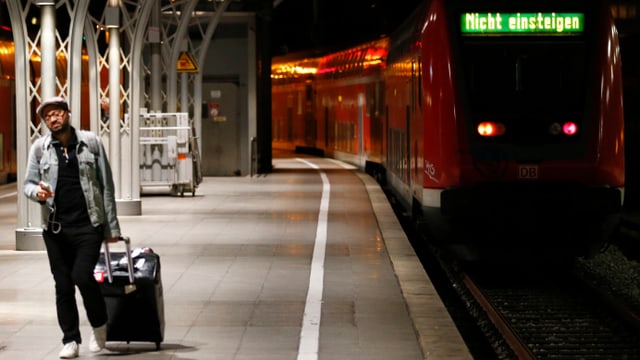 Ein Mann vor einem stehenden Zug. Ein Mann vor einem stehenden Zug.