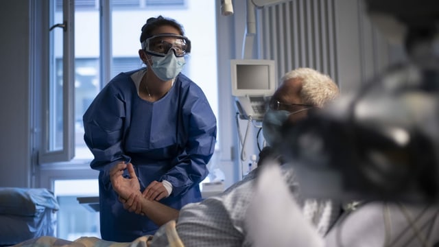 Eine Pflegerin kümmert sich im Universitätsspital Zürich um einen Patienten. Eine Pflegerin kümmert sich im Universitätsspital Zürich um einen Patienten.