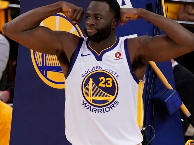 Draymond Green spannt seine Oberarmmuskeln an. Draymond Green spannt seine Oberarmmuskeln an.