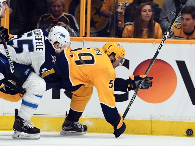 Roman Josi wird an der Bande umgefahren. Roman Josi wird an der Bande umgefahren.