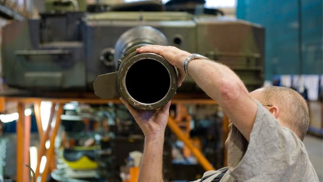 Ein Arbeiter montiert ein Teil am Leopard-Panzer. Ein Arbeiter montiert ein Teil am Leopard-Panzer.