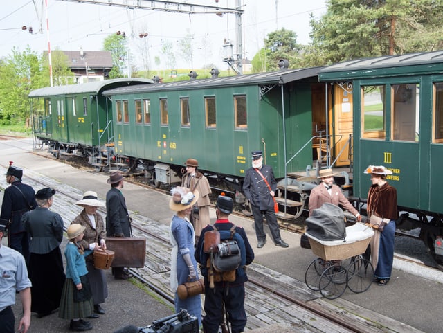 Statisten vor Dampfbahn am Bahnhof