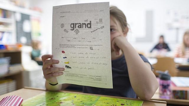 Ein Mädchen hält ein Lernblatt mit französischen Wörtern in der Hand. Ein Mädchen hält ein Lernblatt mit französischen Wörtern in der Hand.