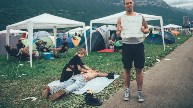 Ein Mann am Greenfield hält ein Schild hoch.