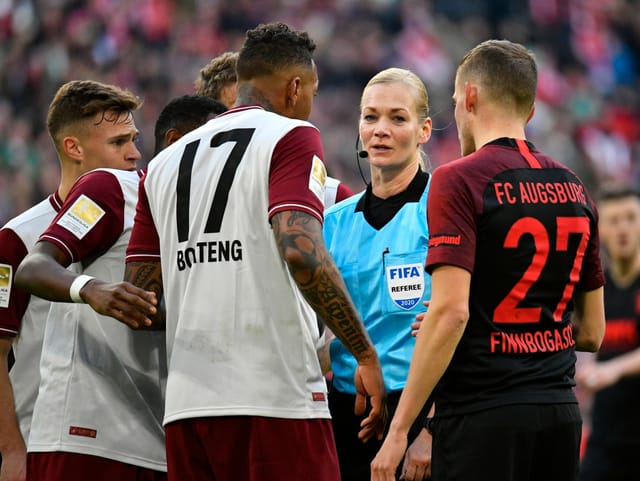 Schiedsrichterin Bibiana Steinhaus umringt von Spielern.