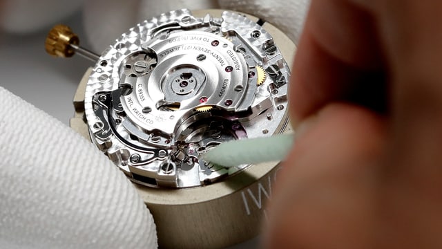 Nahaufnahme eines Uhrwerks, das zusammengesetzt wird Nahaufnahme eines Uhrwerks, das zusammengesetzt wird