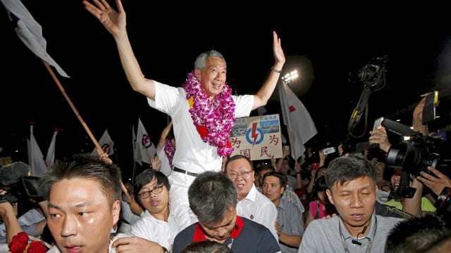Lee Hsien Loong wird von Anhängern getragen. Lee Hsien Loong wird von Anhängern getragen.
