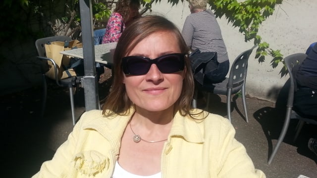 Frau Sibylle Oser sitzt in einem Gartenrestaurant Frau Sibylle Oser sitzt in einem Gartenrestaurant