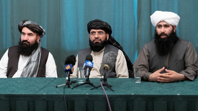 Drei Vertreter der Taliban sitzen nebeneinander an einer Konferenz in Moskau. Drei Vertreter der Taliban sitzen nebeneinander an einer Konferenz in Moskau.
