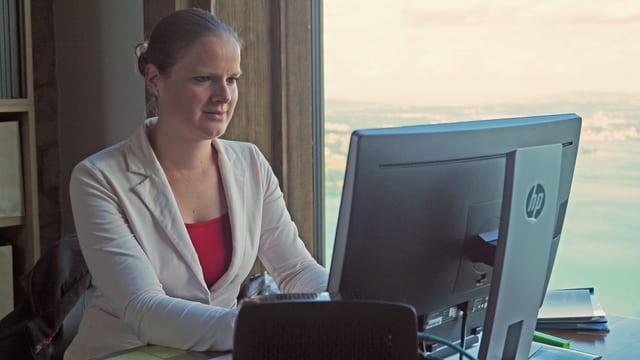Eine Frau sitzt an einem Computer und schreibt. Eine Frau sitzt an einem Computer und schreibt.