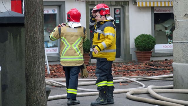 Zwei Feuerwehrmänner zwischen Schläuchen. Zwei Feuerwehrmänner zwischen Schläuchen.