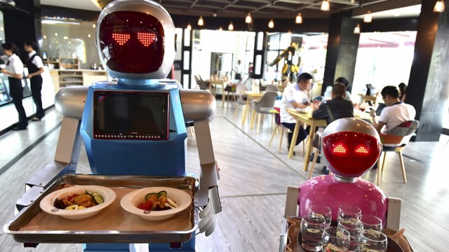 Zwei Roboter servieren Essen Zwei Roboter servieren Essen