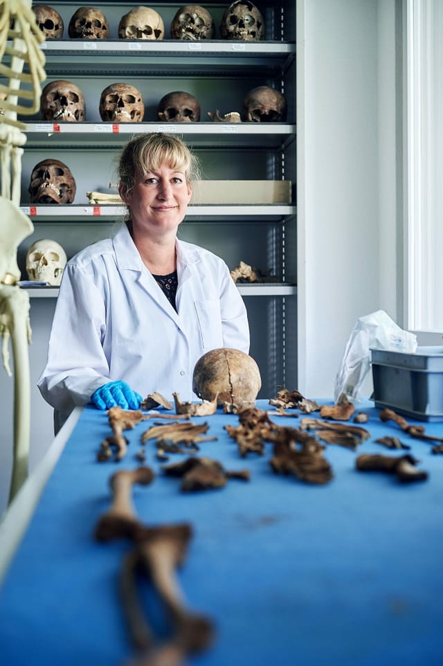 Eine Frau im forensischen Institut. Vor ihr liegen Knochen. Eine Frau im forensischen Institut. Vor ihr liegen Knochen.