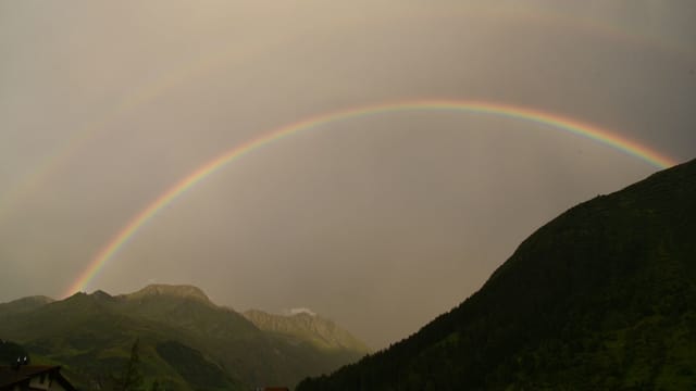 Regenbogen über dem wolkenverhangenen Andermatt Regenbogen über dem wolkenverhangenen Andermatt