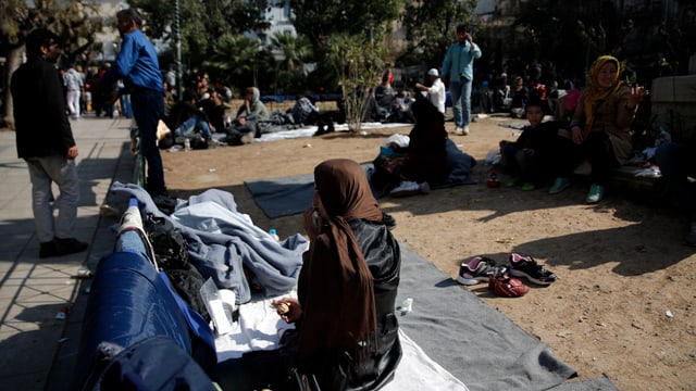 Flüchtlinge sitzen am Boden Flüchtlinge sitzen am Boden