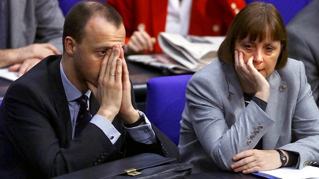 Merz und Merkel sitzen im Jahr 2000 im Reichstag nebeneinander. Merz und Merkel sitzen im Jahr 2000 im Reichstag nebeneinander.