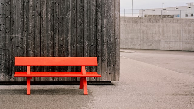 Eine roter Holzbank vor einer Holzwand. Eine roter Holzbank vor einer Holzwand.