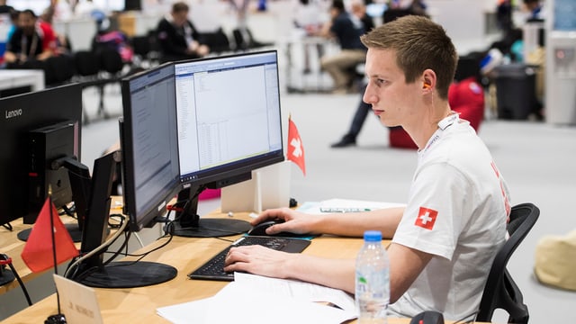 Ein Informatiker arbeitet an zwei Bildschirmen. Ein Informatiker arbeitet an zwei Bildschirmen.