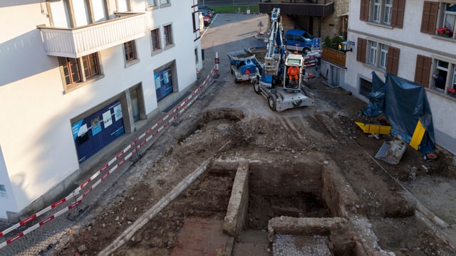 Platz mit historischen Mauern, im Hintergrund Bagger Platz mit historischen Mauern, im Hintergrund Bagger