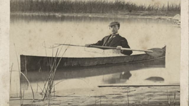 Foto des Jungen im Anzug auf einem Kajak im See. Foto des Jungen im Anzug auf einem Kajak im See.