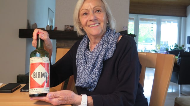 Eine Frau hält eine Flasche Eine Frau hält eine Flasche