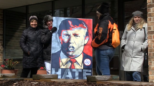 Frauen, die ein gemaltes Donald Trump Porträt halten, darauf steht «Hate» und ein Hackenkreuz ist sichtbar. Frauen, die ein gemaltes Donald Trump Porträt halten, darauf steht «Hate» und ein Hackenkreuz ist sichtbar.
