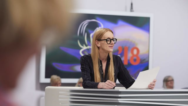 Frau mit langen blonden Haaren und Brille liest von einem Blatt Frau mit langen blonden Haaren und Brille liest von einem Blatt