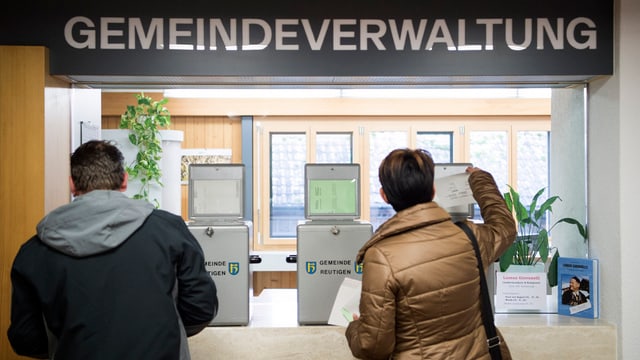 Zwei Leute stimmen bei einer Gemeinde ab. Zwei Leute stimmen bei einer Gemeinde ab.
