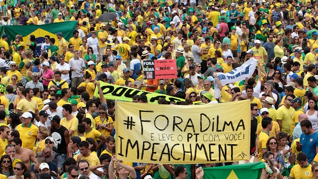Dicht gedrängt stehen Demonstranten mit gelben T-Shirts auf der Strasse und fordern auf Transparenten ein Amtsenthebungsverfahren gegen «Dilma». Dicht gedrängt stehen Demonstranten mit gelben T-Shirts auf der Strasse und fordern auf Transparenten ein Amtsenthebungsverfahren gegen «Dilma».