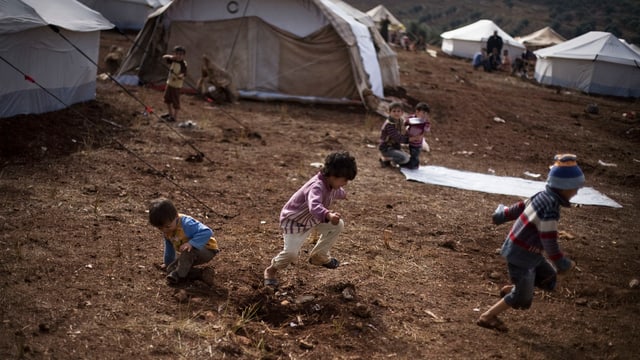 Kinder rennen in einem Flüchtlingscamp in Syrien. Kinder rennen in einem Flüchtlingscamp in Syrien.
