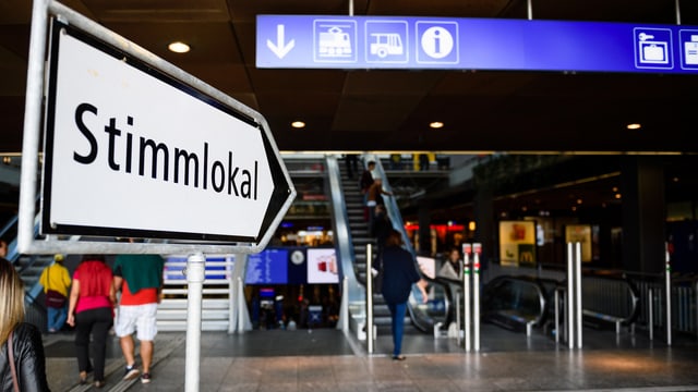 Wegweiser zum Stimmlokal in einer Bahnhofhalle. Wegweiser zum Stimmlokal in einer Bahnhofhalle.