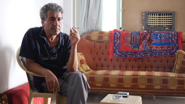 Taha Khalil sitzt rauchend an einem Tisch Taha Khalil sitzt rauchend an einem Tisch