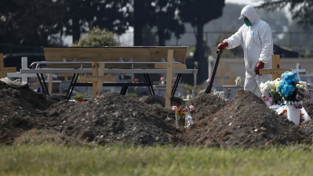 Mann in Schutzanzug auf Friedhof Mann in Schutzanzug auf Friedhof