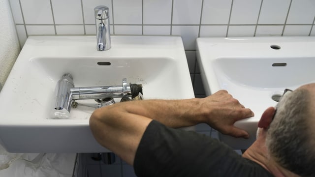Sanitärinstallateur repariert Waschbecken / Symbolbild Sanitärinstallateur repariert Waschbecken / Symbolbild