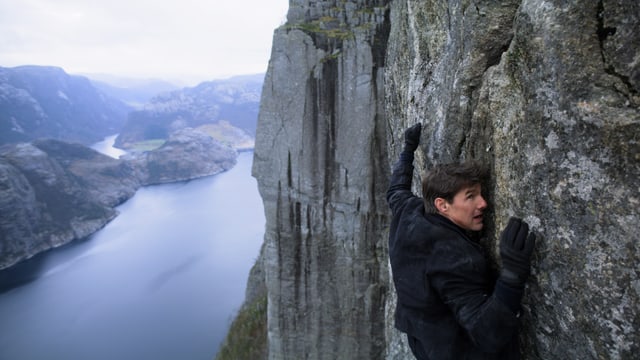 Tom Cruise hält sich an den Felsen einer Klippe fest. Tom Cruise hält sich an den Felsen einer Klippe fest.