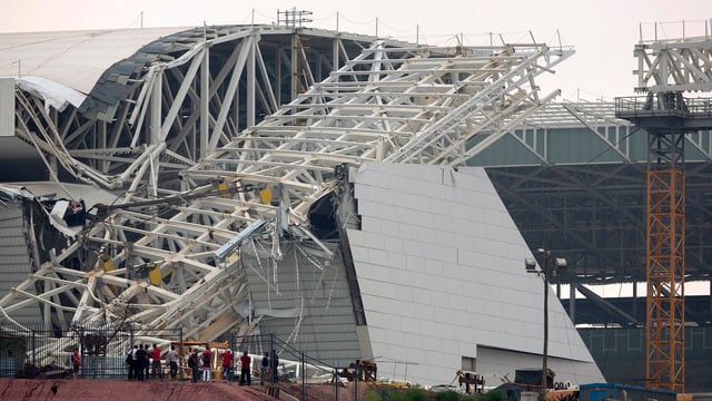 Ein umgekipptes Gerüst hat eine Mauer und das Dach eines Stadions beschädigt. Ein umgekipptes Gerüst hat eine Mauer und das Dach eines Stadions beschädigt.