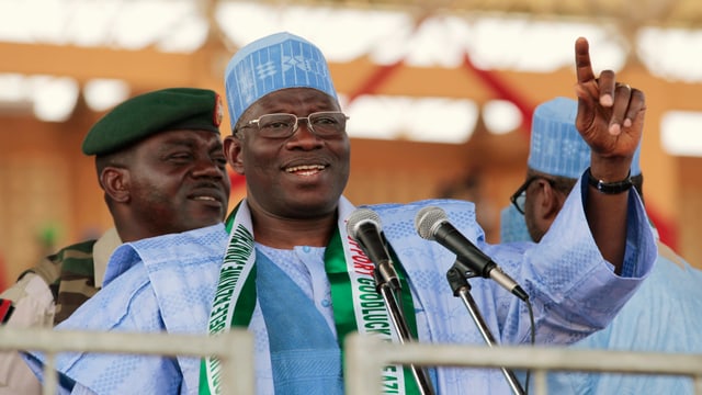 Goodluck Jonathan en vestgì cler blau discura en dus microfons Goodluck Jonathan en vestgì cler blau discura en dus microfons