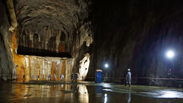 Hohe hölenartige Kaverne mit Bauarbeitern Hohe hölenartige Kaverne mit Bauarbeitern