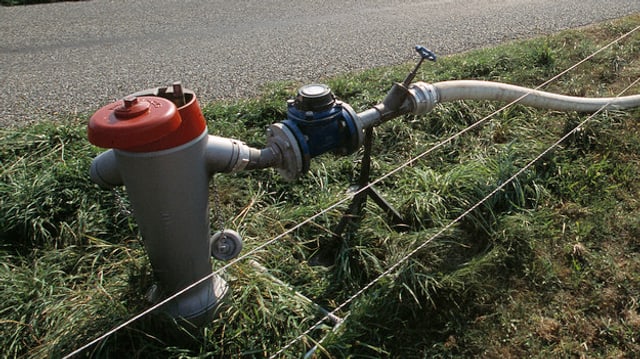 Hydrant in einem Feld, ein Schlauch ist angehängt. Hydrant in einem Feld, ein Schlauch ist angehängt.