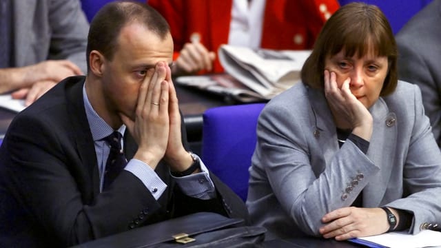 Merz und Merkel sitzen im Jahr 2000 im Reichstag nebeneinander. Merz und Merkel sitzen im Jahr 2000 im Reichstag nebeneinander.