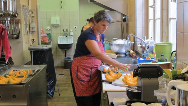 Frau Schorno bereitet in der Küche Melonenschnitze vor Frau Schorno bereitet in der Küche Melonenschnitze vor